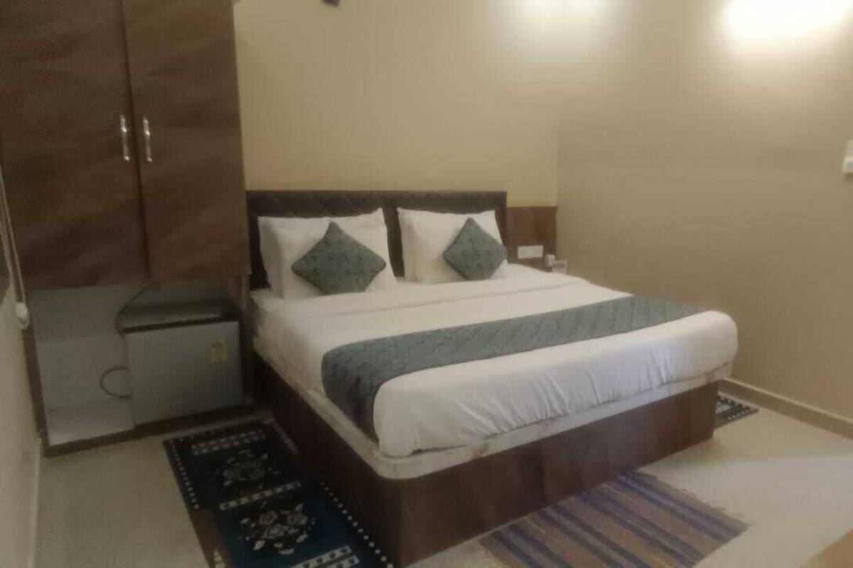 A bedroom with a bed, nightstand, wardrobe, and a door.