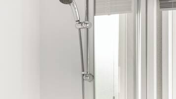 Une douche équipée d’un pommeau de douche à main et d’un flexible.