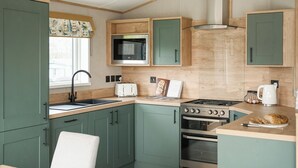 A compact kitchen with a microwave, toaster, stove, and oven.