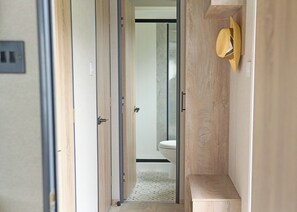 A narrow hallway with wooden doors and a toilet visible in the background. - Premium 2 bed HT Pet (Landford, Nr Salisbury)
