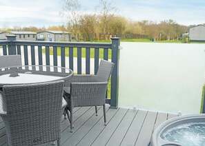 A deck with wicker furniture and a hot tub. - 2 bedroom accommodation in Landford, Nr Salisbury (Landford, Nr Salisbury)