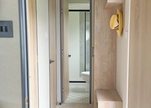 A narrow hallway with wooden doors and a toilet visible in the background. - 2 bedroom accommodation in Landford, Nr Salisbury (Landford, Nr Salisbury)
