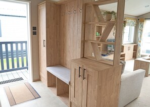 A wooden room with a bench, shelves, and a view of the outdoors. - Exclusive Lodge 4 bed HT (Landford, Nr Salisbury)