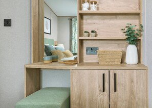 A room with a wooden desk, a mirror, a green bench, and a shelf with decorative items. - Exclusive Lodge 3 bedroom Hot Tub sleeps 6 (Hayle)
