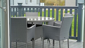 A deck with a round table and four chairs. - 3 bedroom accommodation in Landford, Nr Salisbury (Landford, Nr Salisbury)