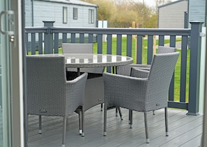 A deck with a round table and four chairs. - 3 bedroom accommodation in Landford, Nr Salisbury (Landford, Nr Salisbury)