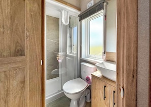 A bathroom with a shower, toilet, sink, and window. - Exclusive Lodge 4 bed HT (Great Yarmouth)