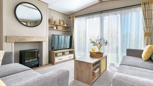 Una sala de estar moderna con chimenea, televisión y asientos cómodos.