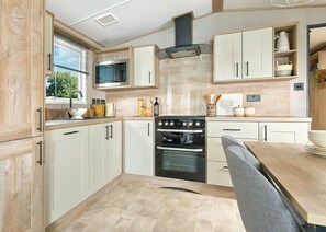 Eine moderne Küche mit Herd, Backofen, Mikrowelle und Holzschränken.