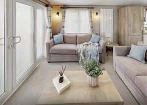 Ein modernes Wohnzimmer mit einer Couch, einem Couchtisch, einer Lampe und einem Topf mit Pflanze.
