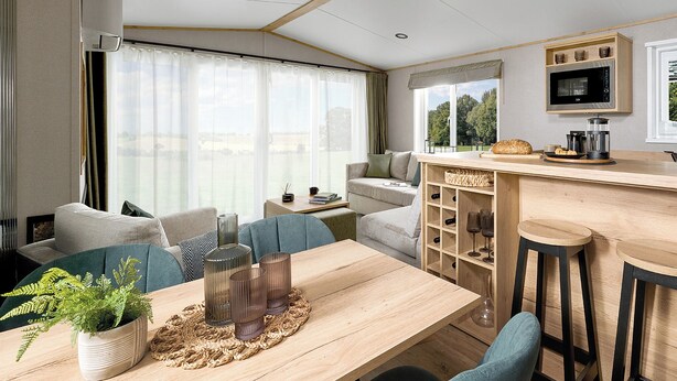 A modern RV interior with a dining area, kitchen, and seating space. - Premium Holiday Home 3 bed HT Pet (Great Yarmouth)