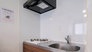 A kitchen with a gas stove, stainless steel sink, and wooden cabinets. - 6 minutes walk from Asakusa Sta. (Sumida City)