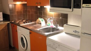 A compact kitchen with a washing machine, dishwasher, microwave, and a sink. - T2 with pool, private parking, walking distance to the beach - 4 pers - ARGELES SUR MER (Argelès-sur-Mer)