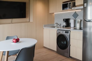 A compact kitchen with a washing machine, a microwave, and a coffee maker. - Modern 1BR in Juárez with fast WiFi, great natural light, a comfortable king bed, a fully equipped kitchen, and a luxury bathroom. Perfect for couples or solo travelers seeking comfort, style, and a prime location in Mexico City. (Cuauhtémoc)