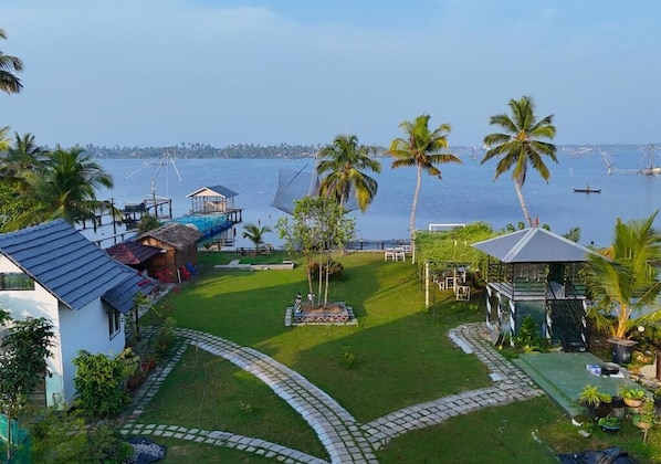 A coastal property with a swimming pool, a gazebo, and a view of the sea.