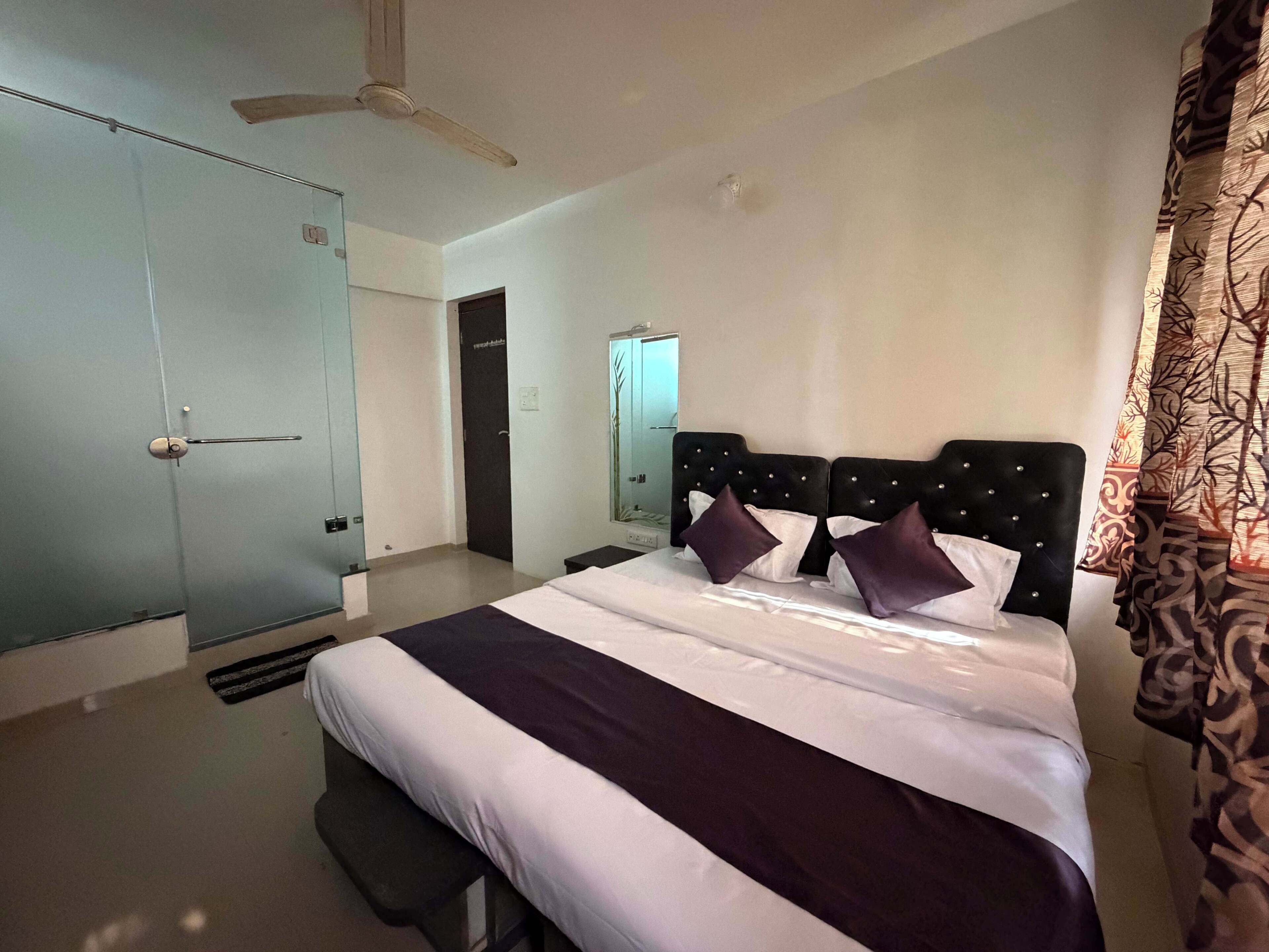 Un dormitorio con cama, ventilador de techo, armario y puerta.
