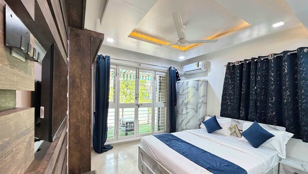 Un dormitorio moderno con una cama grande, un ventilador de techo y vistas al exterior.