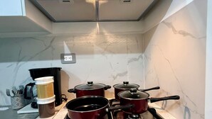 A kitchen with a Whirlpool stove, a coffee maker, and a set of pots. - Enjoy your getaway at this unique, private, quiet and safe residential house! (San Miguel)