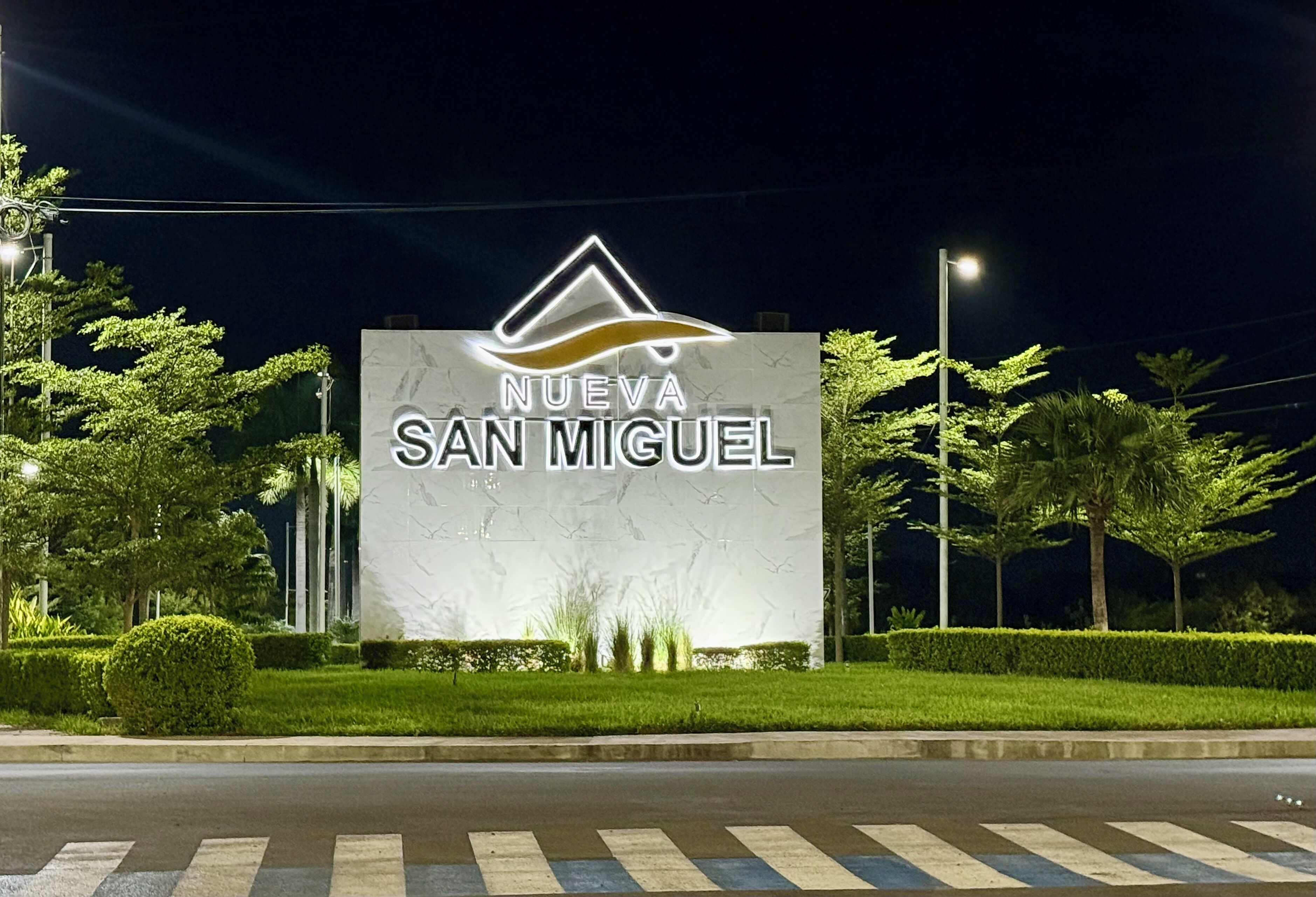 Un grand panneau lumineux avec l’inscription « NUEVA SAN MIGUEL » et un logo représentant un sommet de montagne stylisé.