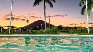 A swimming pool with palm trees and a mountain in the background. - Enjoy your getaway at this unique, private, quiet and safe residential house! (San Miguel)