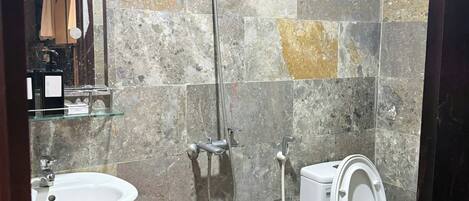 A bathroom with a sink, toilet, and shower.
