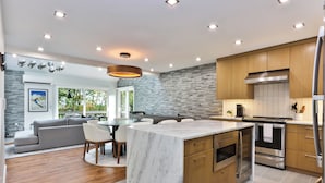 A modern kitchen with a marble island, wooden cabinets, stainless steel appliances, and recessed ceiling lighting. - Ski in/out @ Camelback: Sleeps up to 16 (Tannersville)