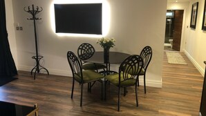 A dining area with a table and chairs, a coat rack, and a wall-mounted TV. - Private Lodge With Hot tub in Blackpool (Blackpool)