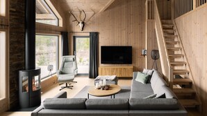 Una sala de estar moderna con chimenea, un sofá, un televisor y una escalera.