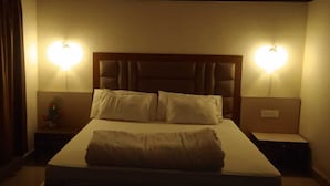 A hotel room with a bed, two bedside tables, and two wall-mounted lamps. - Hotel City Palace (Ranchi)