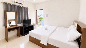 Habitación de hotel con cama, televisor, escritorio y ventana con vistas.