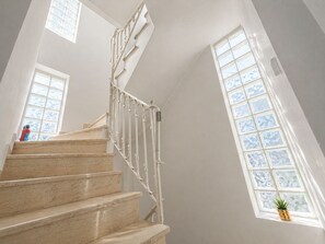 A staircase with white railings, a fire extinguisher, and a potted plant. - Chalandri Spacious 4BR 3-Level Maisonette by ΜΡS (Chalandri)