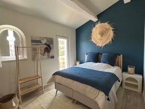 A bedroom with a bed, a wooden ladder, a painting, a woven light fixture, and a window. - Villa Jardin Azur - Pool - Gulf of St-Tropez (Roquebrune-sur-Argens)