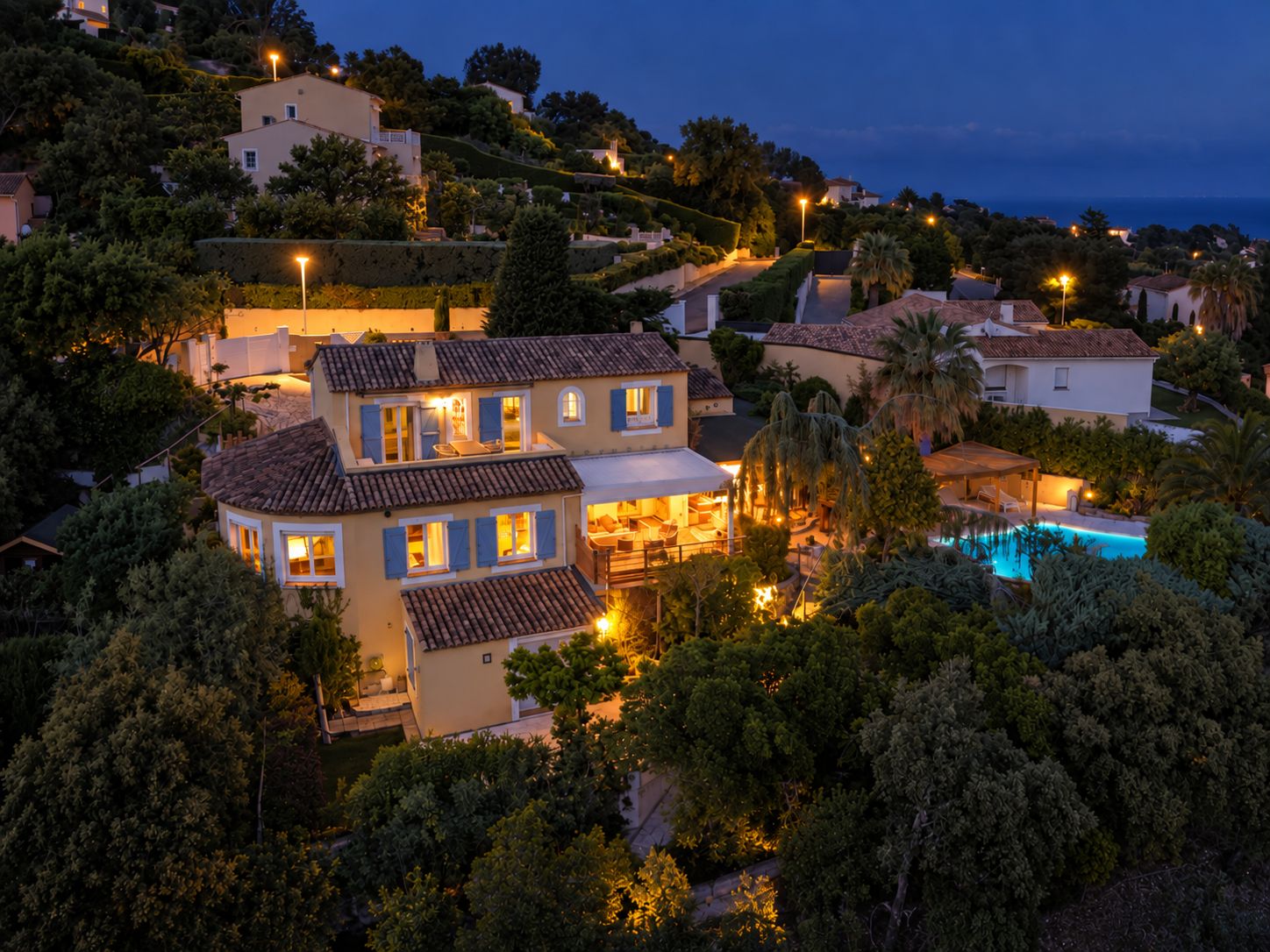 A residential property with multiple houses, a swimming pool, and a well-maintained garden.