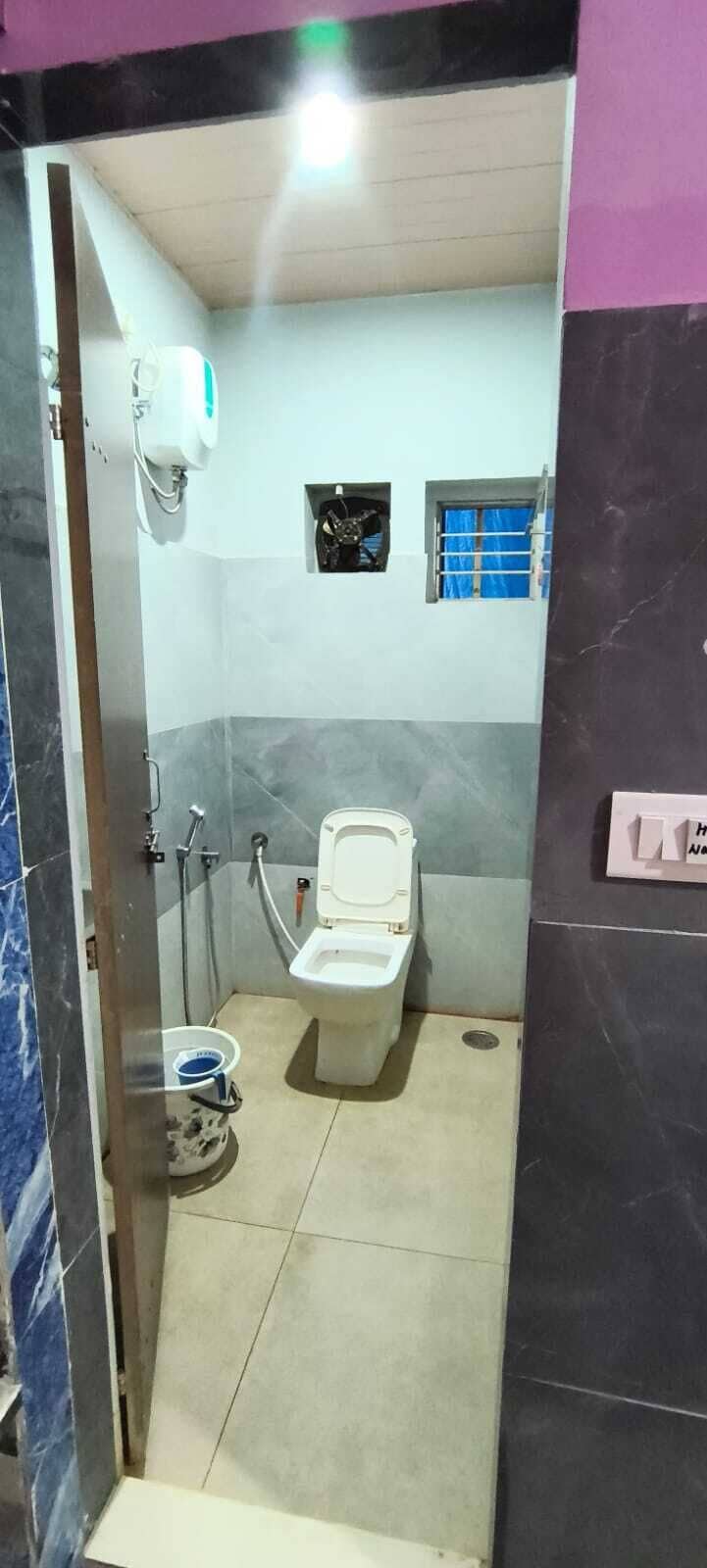 Un baño pequeño con inodoro, ducha y ventana.