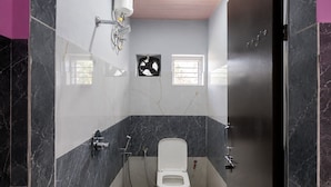 A bathroom with a toilet, a shower, a towel rack, and a window. - SVS Grands (Atreyapuram)