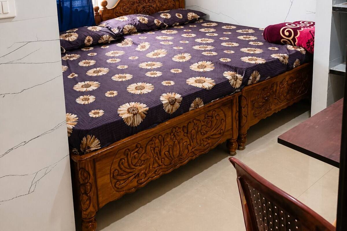 Quarto com cama, ventoinha no teto, janela com cortinas e ar-condicionado fixado na parede.