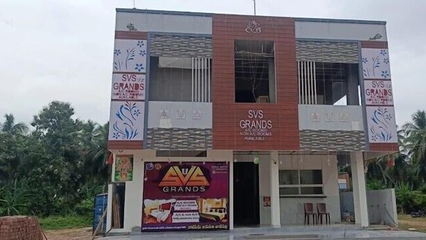 A two-story building with 'SVS GRANDS' signage, a visible entrance, and a signboard advertising 'AVA GRANDS.' - SVS Grands (Atreyapuram)