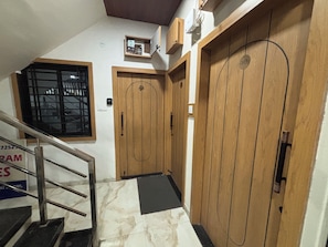 Una escalera que conduce a una puerta de madera con un ventanal encima.
