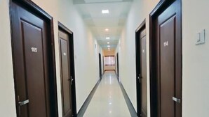 A long, narrow hallway with doors numbered 105 and 114, leading to rooms.