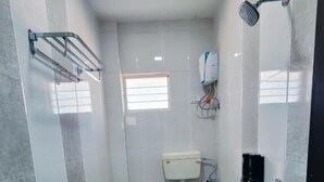 A bathroom with a toilet, a shower, and a sink.
