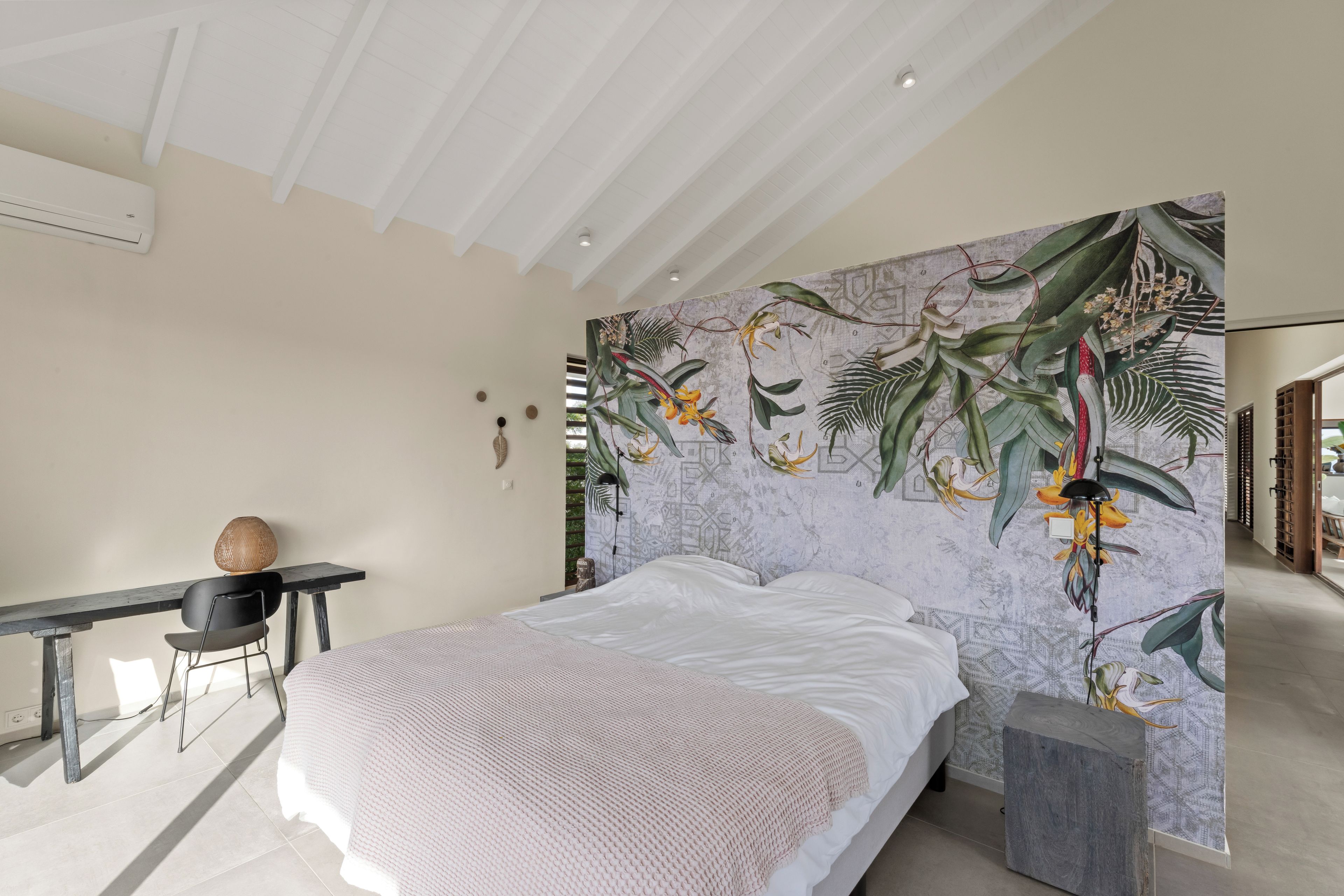 A bedroom with a bed, a desk, and a chair.