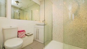 A bathroom with a toilet, a sink, a glass shower enclosure, and a mirror. - Detached 5-Bed with Games Room · Quedgeley near Gloucester · Sleeps 10 (Quedgeley)