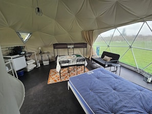 A tented accommodation with bunk beds, a desk, a chair, and a view of the outdoors. - Sherwood Pines - Geodome (Mansfield)