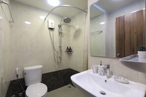 A modern bathroom with a toilet, shower, and sink. - Studio Green View near Yanui Beach | CapitalPro (Rawai)