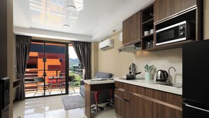 Een moderne keuken met een inbouwmagnetron, een koffiezetapparaat en een eethoek met een tafel en stoelen.