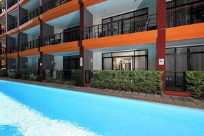 A multi-story hotel with balconies, a swimming pool, and a modern architectural design. - Studio Pool Access Nai Harn Beach Capital Pro (Rawai)