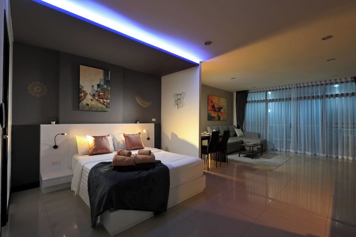 Un dormitorio moderno con cama, mesitas de noche, un escritorio y una silla.