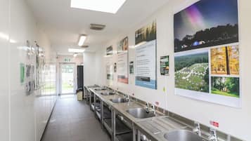 Des toilettes publiques propres et bien éclairées, équipées de plusieurs lavabos et de sèche-mains, ainsi que d’affiches informatives sur les murs.