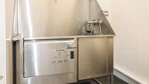 Uma pia de aço inoxidável para cozinha profissional, com painel de controle e torneira.