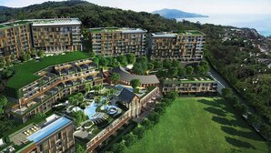 A modern hotel complex with multiple buildings, a central courtyard, and a pool area. - 1BR Mountain View Apartment Surin | CapitalPro (Surin)